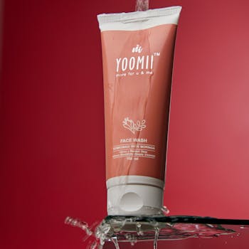 Inicio Elegant face wash tube with flowing water on a red background, highlighting beauty and skincare.