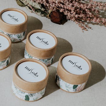 Inicio Flat lay of stylish botanical skincare containers with floral accents.